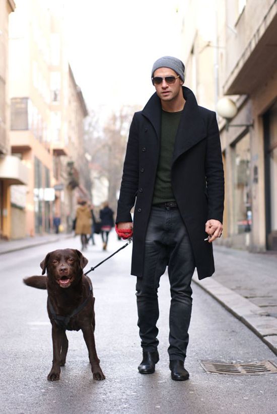 мужчина в черном пальто с собакой